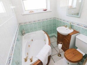 A bathroom with a bathtub, a sink, and a toilet. - Castle Grove (Milford Haven)
