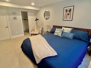 A bedroom with a large bed, a chair, a bedside table, and a mirror on the wall. - Bright & Spacious Sundance Home with Dedicated Office & Gym (Boulder)