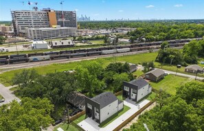 An aerial view of a train station with multiple tracks, surrounded by greenery and residential buildings. - New 3BR/2.5BA Near LBJ Hospital - Corporate & Extended Stays (Houston)