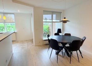 A modern kitchen with a dining area, large windows, and a view of greenery. - Bright apartment at the heart of Kópavogur (Kópavogur)