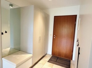 Ein Zimmer mit Schrank, Tür und Fliesenboden.