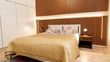 A bedroom with a bed, nightstands, a wooden slatted headboard, and a wardrobe.