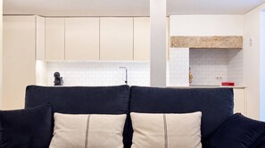 A modern kitchen with white tiles, a built-in oven, and a red appliance on the counter. - VIVA Lapa Serviced Apartments (Lisboa)