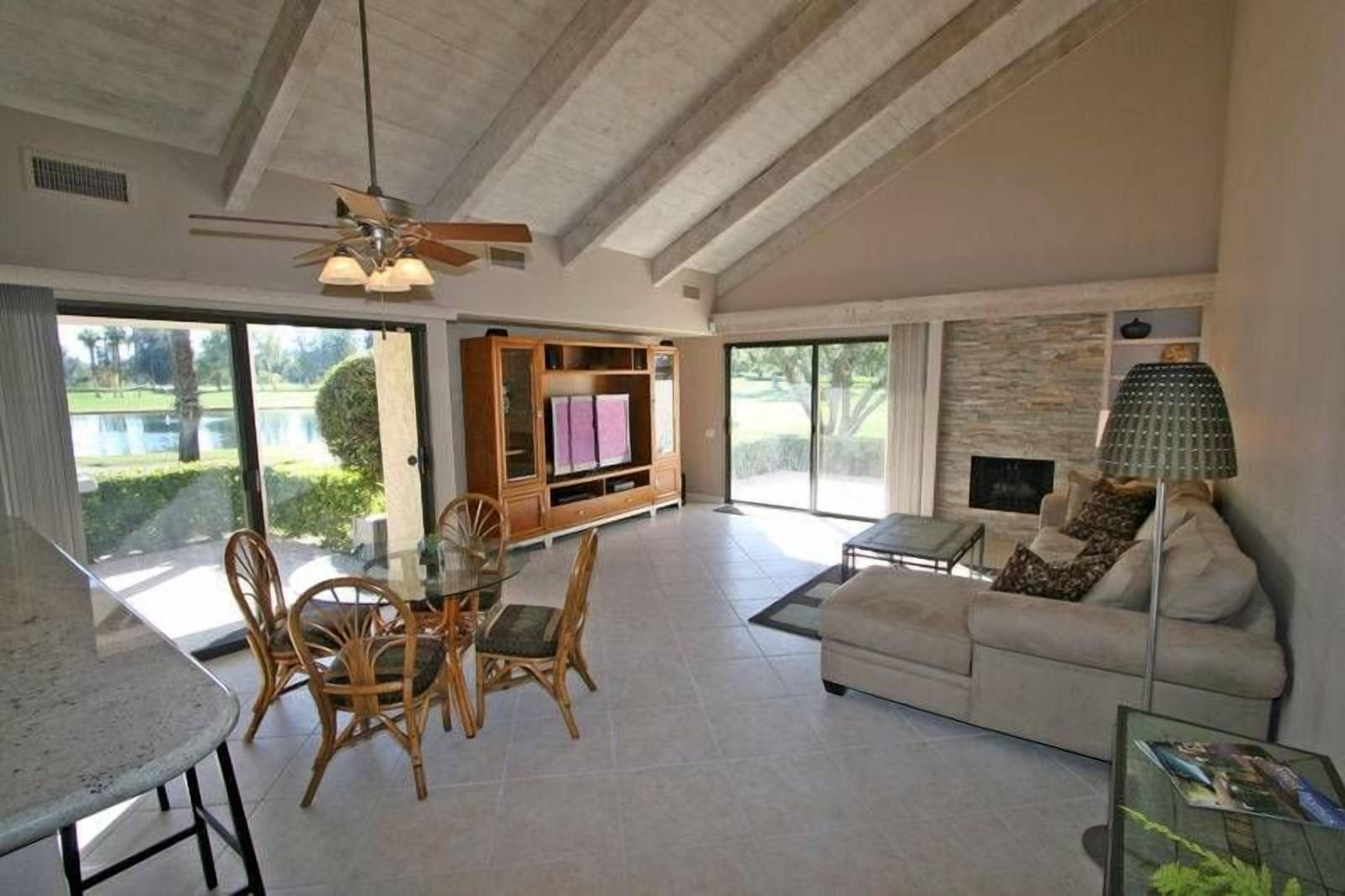 A spacious living area with a dining table, chairs, a sofa, and a fireplace.