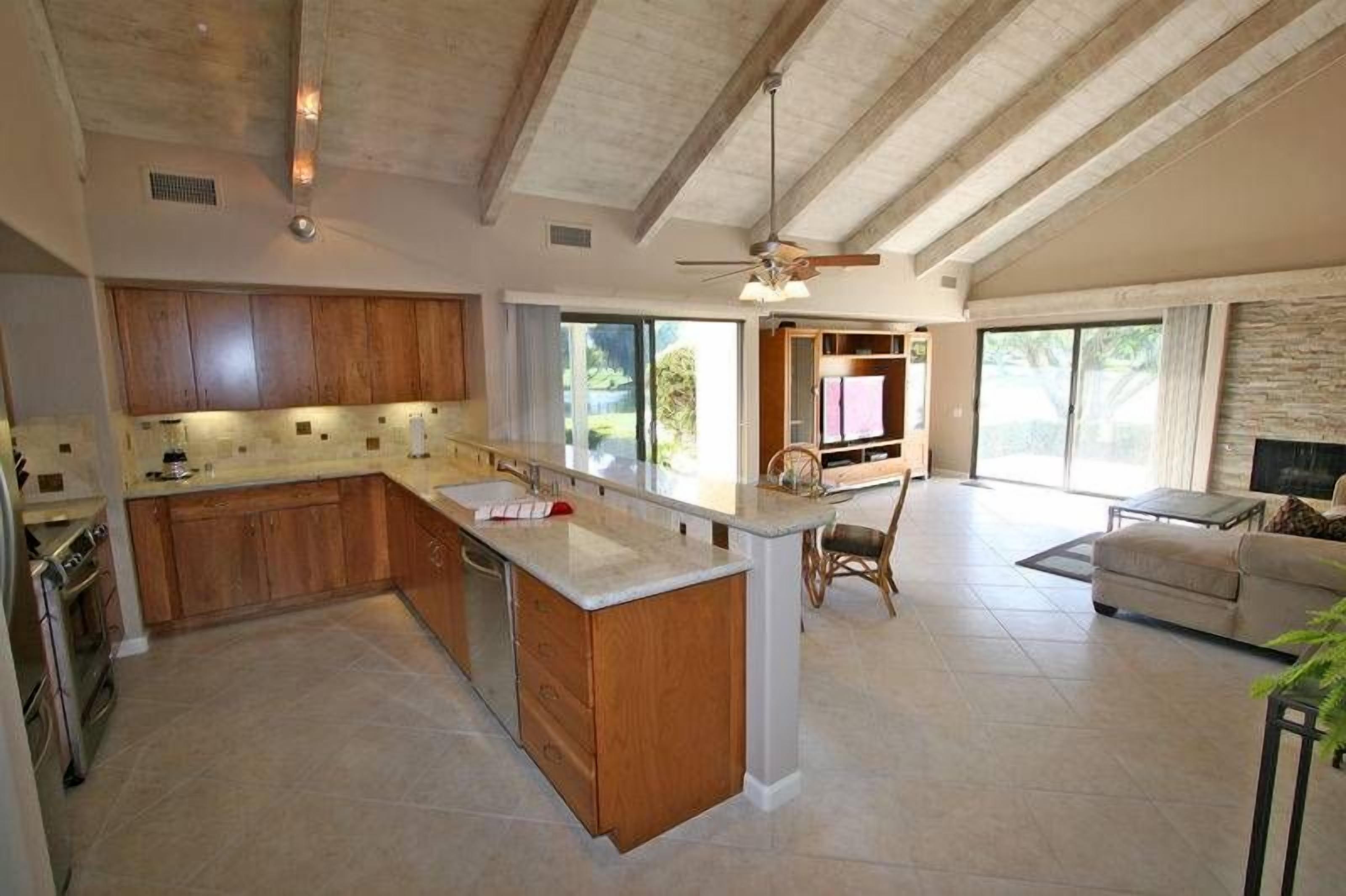 Un'ampia cucina con isola centrale, mobili in legno e una grande finestra che offre luce naturale.