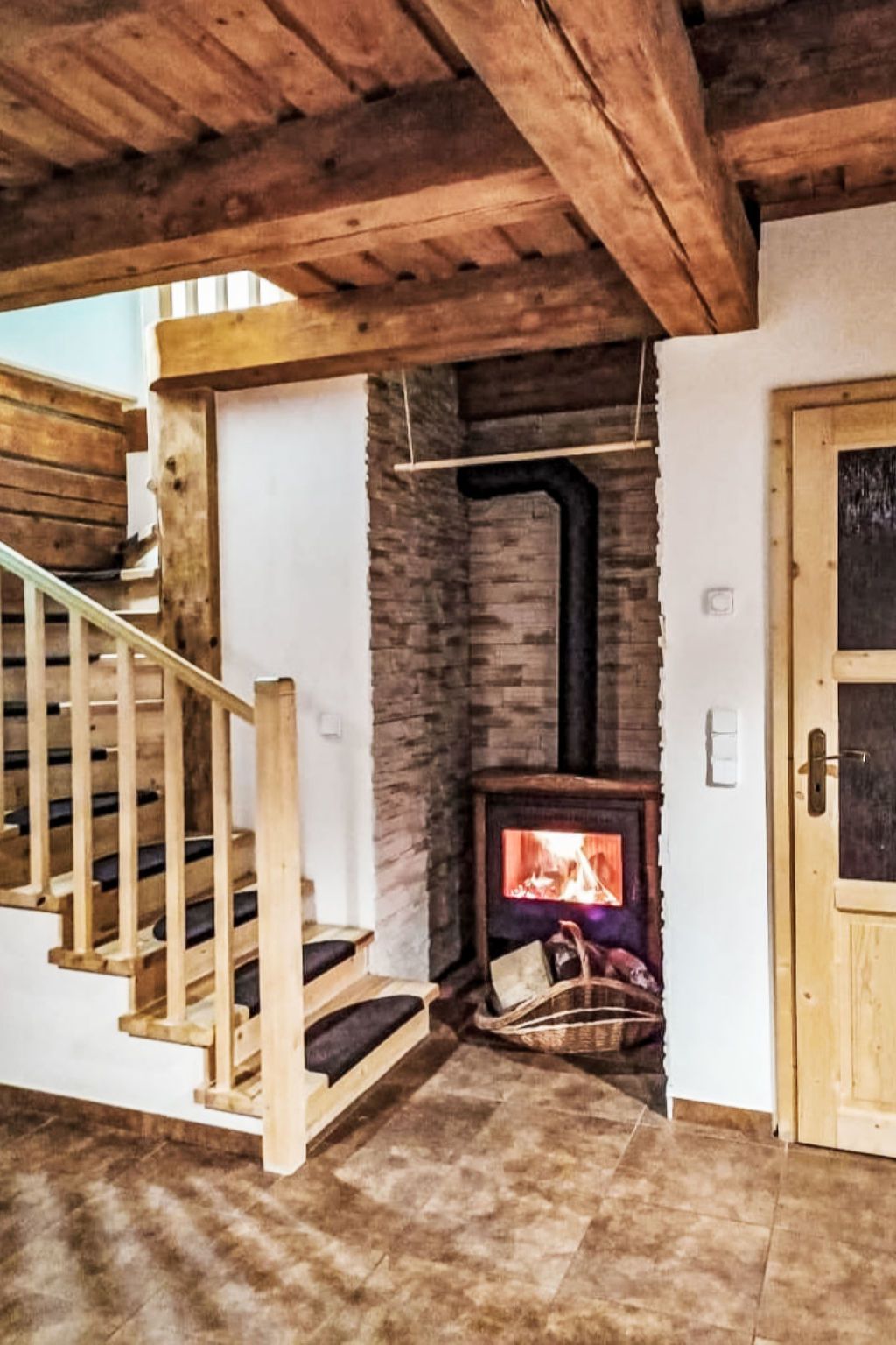A wooden staircase leading to a loft area with a fireplace.