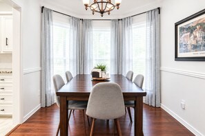 A dining room with a wooden table, six chairs, and a chandelier. - Artsy Retreat: 3BR Home - King Bed, 2-Car Garage, Patio + Firepit (Lubbock)