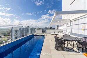 A rooftop pool area with a clear view of the city skyline, a seating area, and a pergola structure. - Apt. w/ Sea View in Condo. w/ Pool Ltt0704 (Picarras)