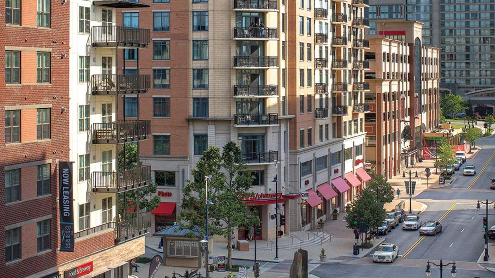 A multi-story building with balconies, a street view, and a CVS pharmacy.