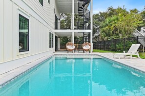 A swimming pool with two wicker chairs and a white lounge chair. - The Lookout at Betty (Santa Rosa Beach)