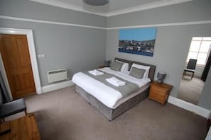 A bedroom with a bed, bedside tables, a chair, and a painting on the wall. - The Royal Hotel Stromness (Stromness)