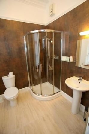 A bathroom with a glass-enclosed shower, a white sink, and a toilet. - The Royal Hotel Stromness (Stromness)