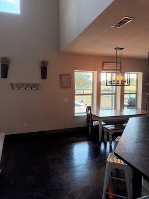 A kitchen with a large window, a hanging light fixture, and a wall-mounted vent. - Perfect 6-bedroom barn with Pool in lovely McKinney (McKinney)