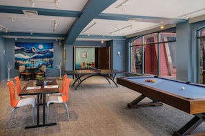 A pool table, dining area, and a mural in a room with blue walls and a carpeted floor. - Cozy Christmas Ski Getaway \ Sheraton Steamboat Studio \ Dec 25–30 (Steamboat Springs)