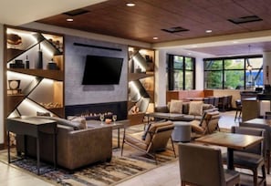 A modern lounge area with a fireplace, comfortable seating, and a flat-screen TV mounted on the wall. - Cozy Christmas Ski Getaway \ Sheraton Steamboat Studio \ Dec 25–30 (Steamboat Springs)