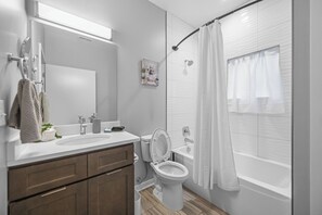Une salle de bain moderne avec un meuble-lavabo à deux vasques, des toilettes et une baignoire.