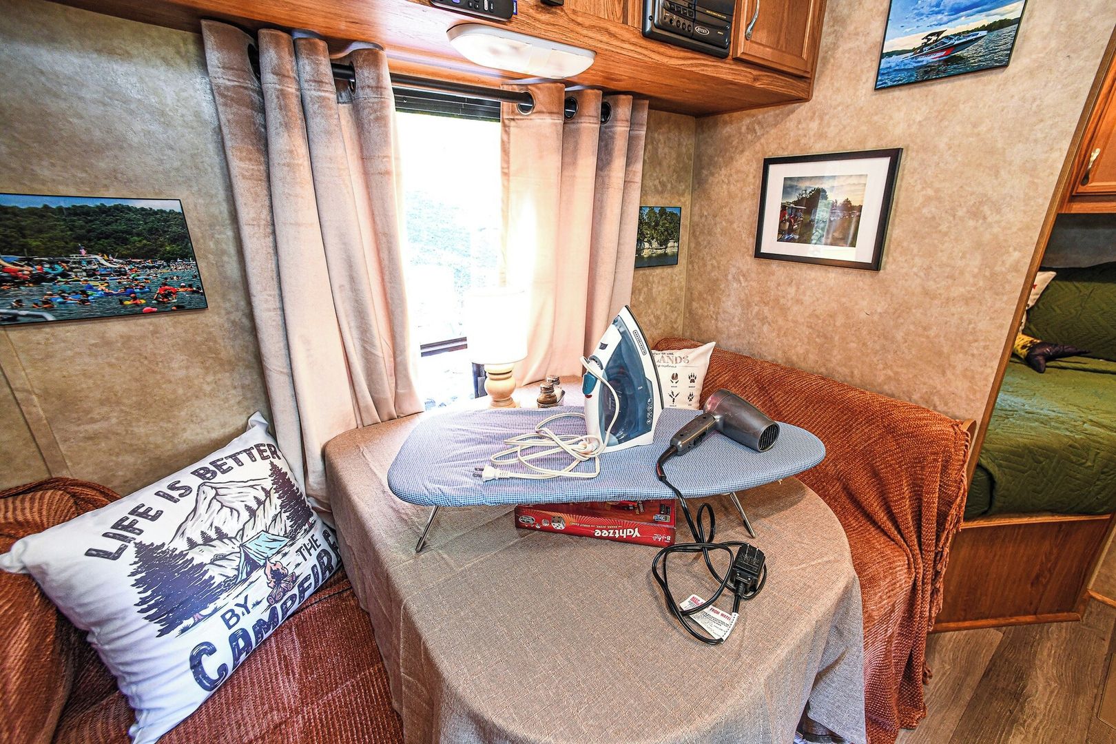 A compact kitchenette with a small table, an iron, and a hairdryer.