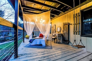 Quarto com cama de dossel, escrivaninha e cadeira balanço.