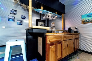Cozinha com bancada de madeira, luminária pendente e geladeira.