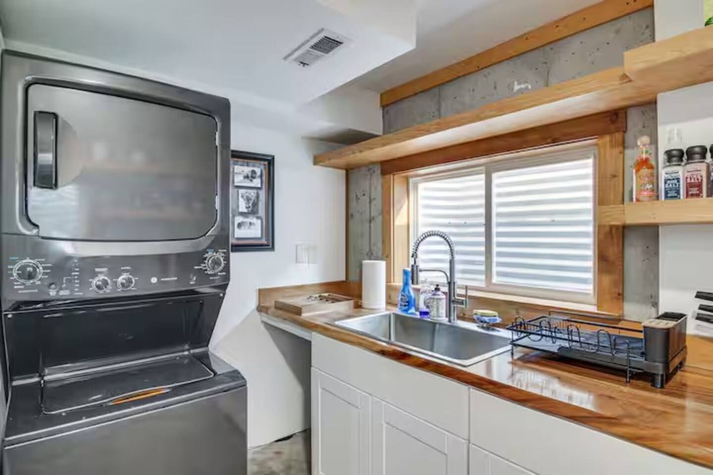 A kitchen with a built-in stove, a sink, and wooden countertops.