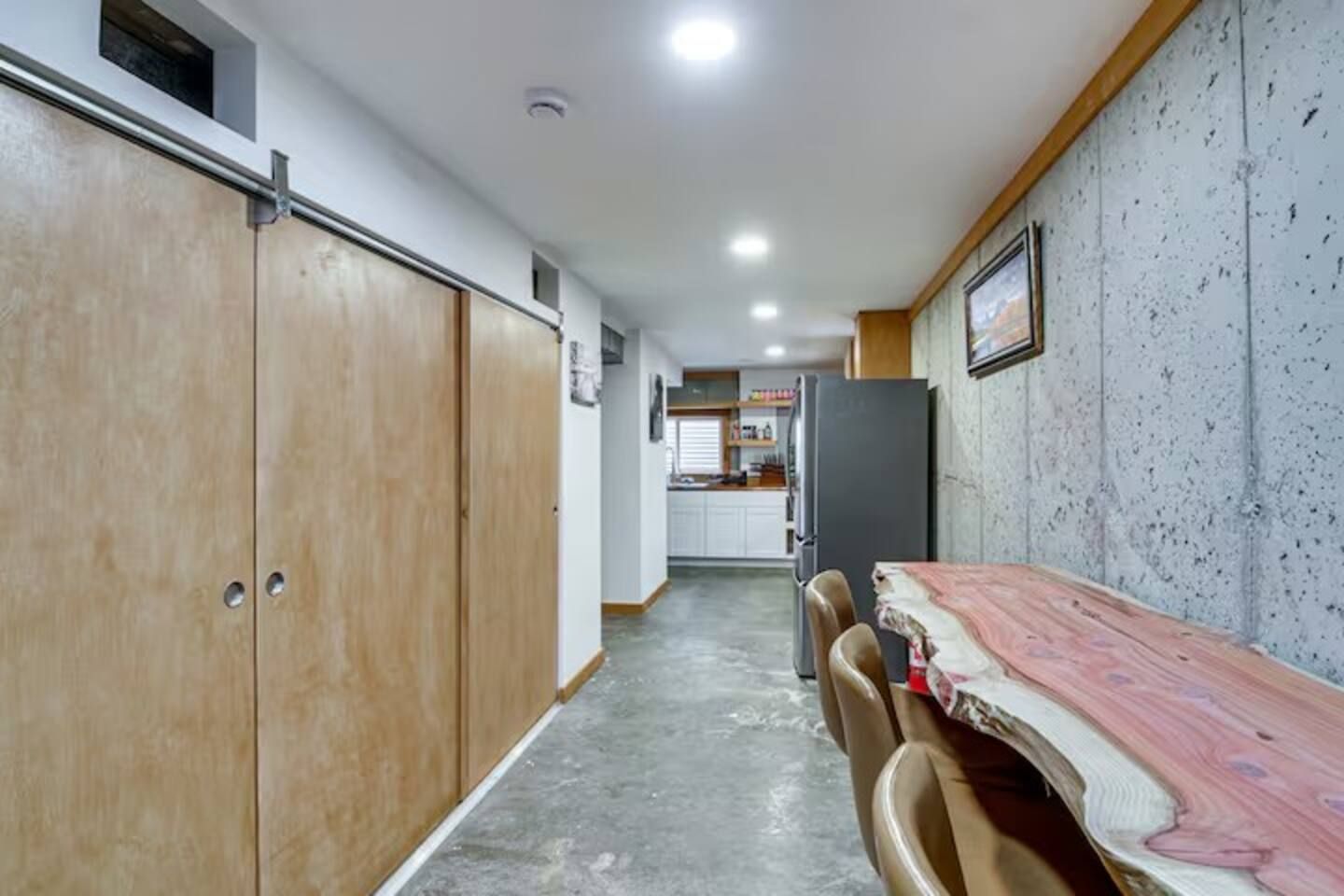 Un couloir mène à une cuisine qui comprend un coin repas avec une table et des chaises.