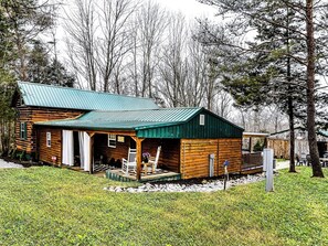 A log cabin with a green metal roof, a porch, and a small deck. - Hill-Billy Hilton Cabin near Mammoth Cave and Nolin Sleeps 16 (Clarkson)