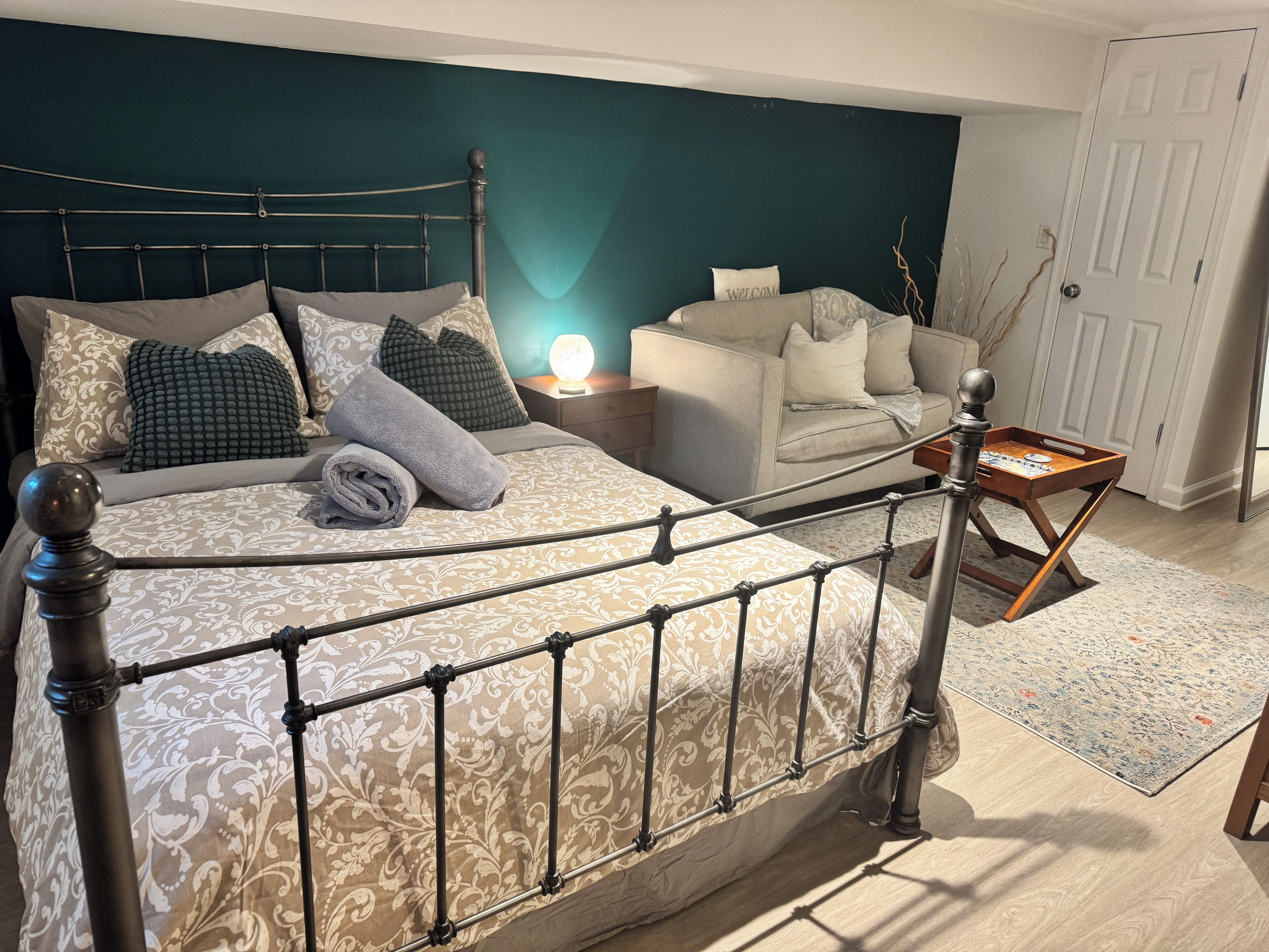 A neatly arranged bedroom with a bed, nightstand, and a small wooden table.