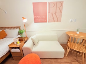 A bedroom with a bed, a white sofa, a wooden nightstand with a lamp, a small table with a plant, and a wall with 'PRAY' and 'PSALM 46:5' text. - Stay in Trendy Yongsan /Seoul /3-min walk to Subway & Airport Bus (Seoul)