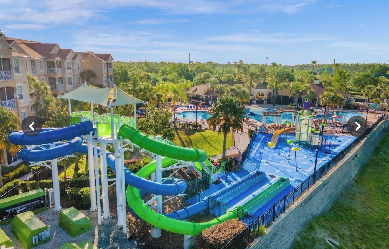 A water park with multiple slides and pools, surrounded by residential buildings and greenery.