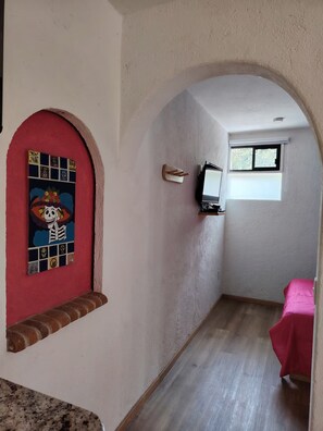 A narrow hallway with a red door and a window. - A minimalist and functional loft in the Mexican style, located in the heart of Coyoacán (Ciudad de México)