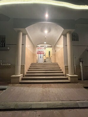 A staircase leading to a building entrance with a signboard above. - Luxury Modern Apartment  Near Alharam  And Airport (Madinah)