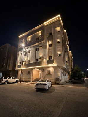 A multi-story building with a modern design, featuring a prominent entrance with steps and a flat roof. - Luxury Modern Apartment  Near Alharam  And Airport (Madinah)