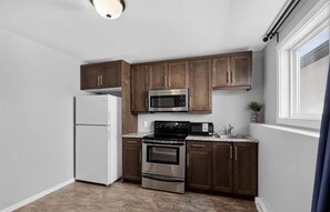 A compact kitchen with a refrigerator, microwave, stove, and oven. - 3 Spacious private bedroom self contained space with own private entrance. (Steinbach)