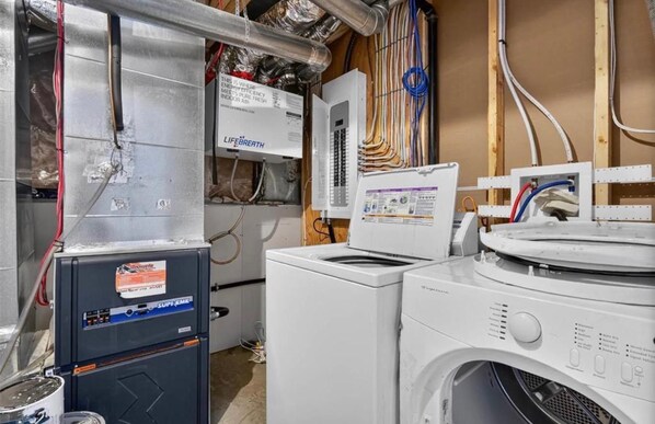A laundry room with a washing machine, dryer, and a LifeBreathe air purifier.