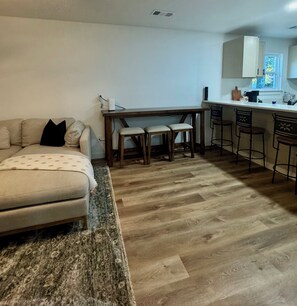 Ein Wohnzimmer mit einer Couch, einem Couchtisch und einem Essbereich mit Tisch und Stühlen.