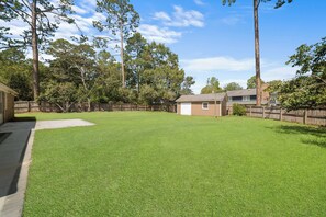 A backyard with a well-maintained lawn, a small shed, and a wooden fence. - GSU Hospital Haven: located near everything! (Statesboro)