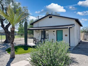 A small white building with a green door, a patio with chairs, and a cactus in the foreground. - Casita Anita Historic Adobe Near Downtown Tucson (Tucson)