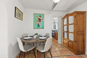 Ein Essbereich mit einem runden Tisch, Stühlen und einem Holzschrank.