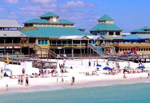 A beachside resort with multiple buildings, a sandy beach, and a pier. - Palm Court Yacht Club 312a - Studio by the Sea (Fort Walton Beach)