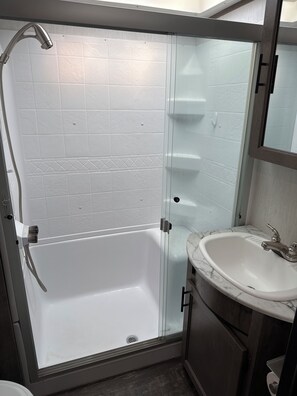 A bathroom with a glass-enclosed shower, a white bathtub, a marble sink, and a wooden cabinet. - Spacious countryside retreat in peaceful Paso Robles (Paso Robles)
