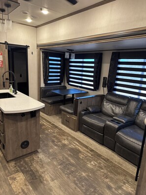 A compact RV interior with a kitchenette, seating area, and large windows. - Spacious countryside retreat in peaceful Paso Robles (Paso Robles)