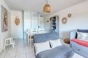 A modern bedroom with a bed, a dresser, a chair, and a small table. - T2 in Lavandou - Residence with Swimming Pool (Le Lavandou)