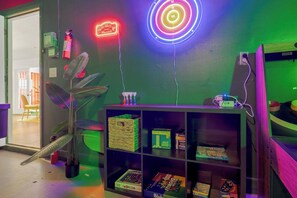 A room with a bookshelf, a neon sign, and a plant. - 4 Min to Beach! 85°F Pool•Sauna•Golf•Pickleball (Seminole)