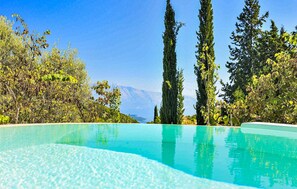 A clear blue pool with a mountain view in the background. - Luxurious home in Lefkada with private swimming pool, can be inside or outside (Lefkada)