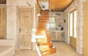 A wooden staircase leading to a kitchen area with stone walls and a wooden door labeled 'TOILET'. - Cozy home in Lefkada with private swimming pool, can be inside or outside (Lefkada)