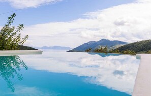 Ein klares Infinity-Pool mit einer Bergkulisse im Hintergrund.