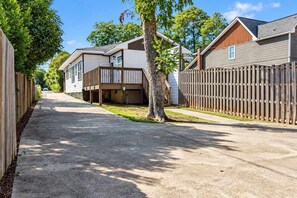 Una calle residencial con casas, una valla de madera y un árbol.