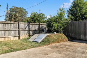 A backyard with a wooden fence, a concrete ramp, and a grassy area. - Southern Row | Two King Bedrooms | Walk to UA (Tuscaloosa)