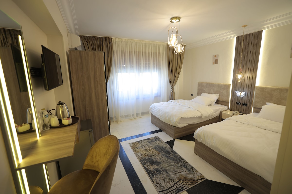 Una habitación de hotel con cama, escritorio, silla, televisor y baño.