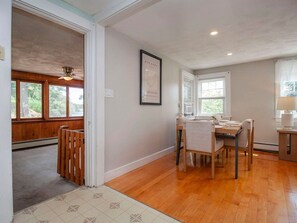 A dining area with a wooden table and chairs, a ceiling fan, and a window with blinds. - Derry Retreat w Private Hot Tub & Outdoor Space! (Derry)